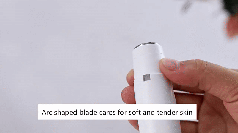 White hair trimmer with a rounded arc-shaped blade, held in one hand