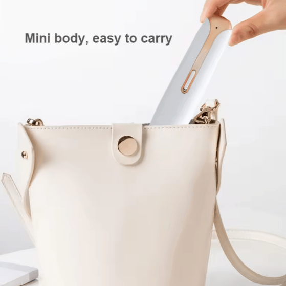White 4-in-1 hair trimmer with a slim handle being placed in a beige handbag