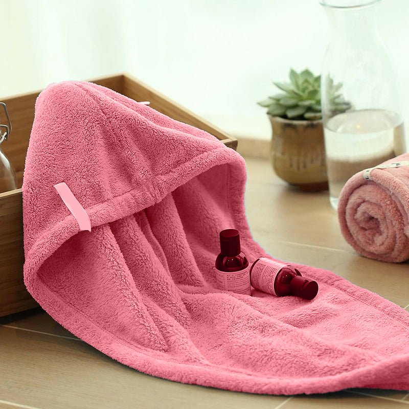 Pink hair drying cap towel opened to show its hood shape, loop, and soft textured fabric.