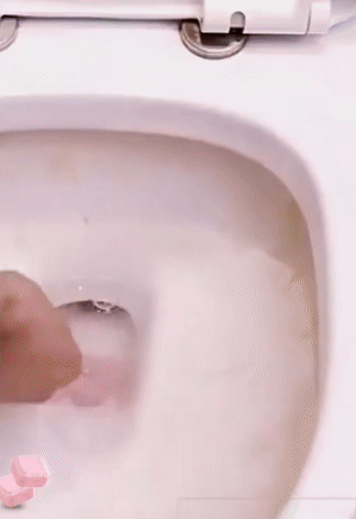 Toilet bowl tablet being placed into water inside a toilet