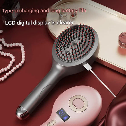Silver massage spray comb with USB-C charging cable beside a pink model