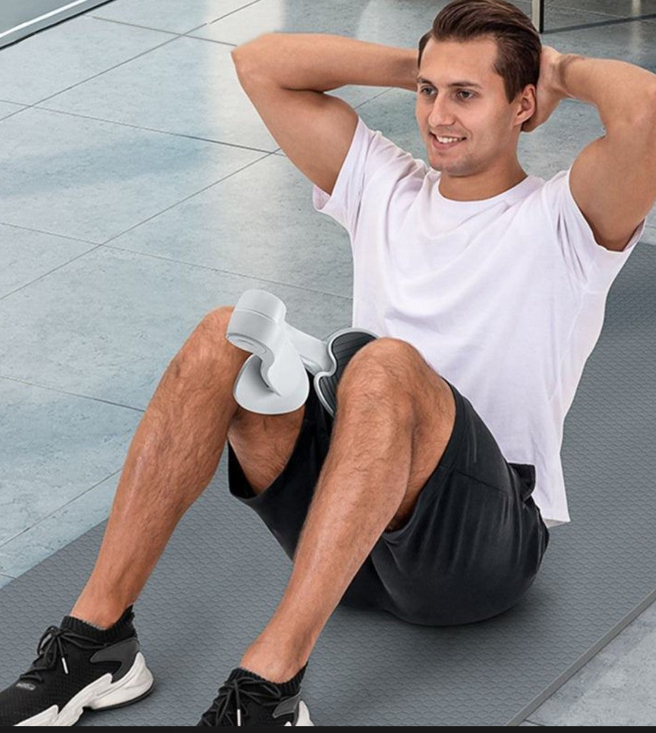 Gray pelvic floor muscle trainer positioned between a man's knees during exercise